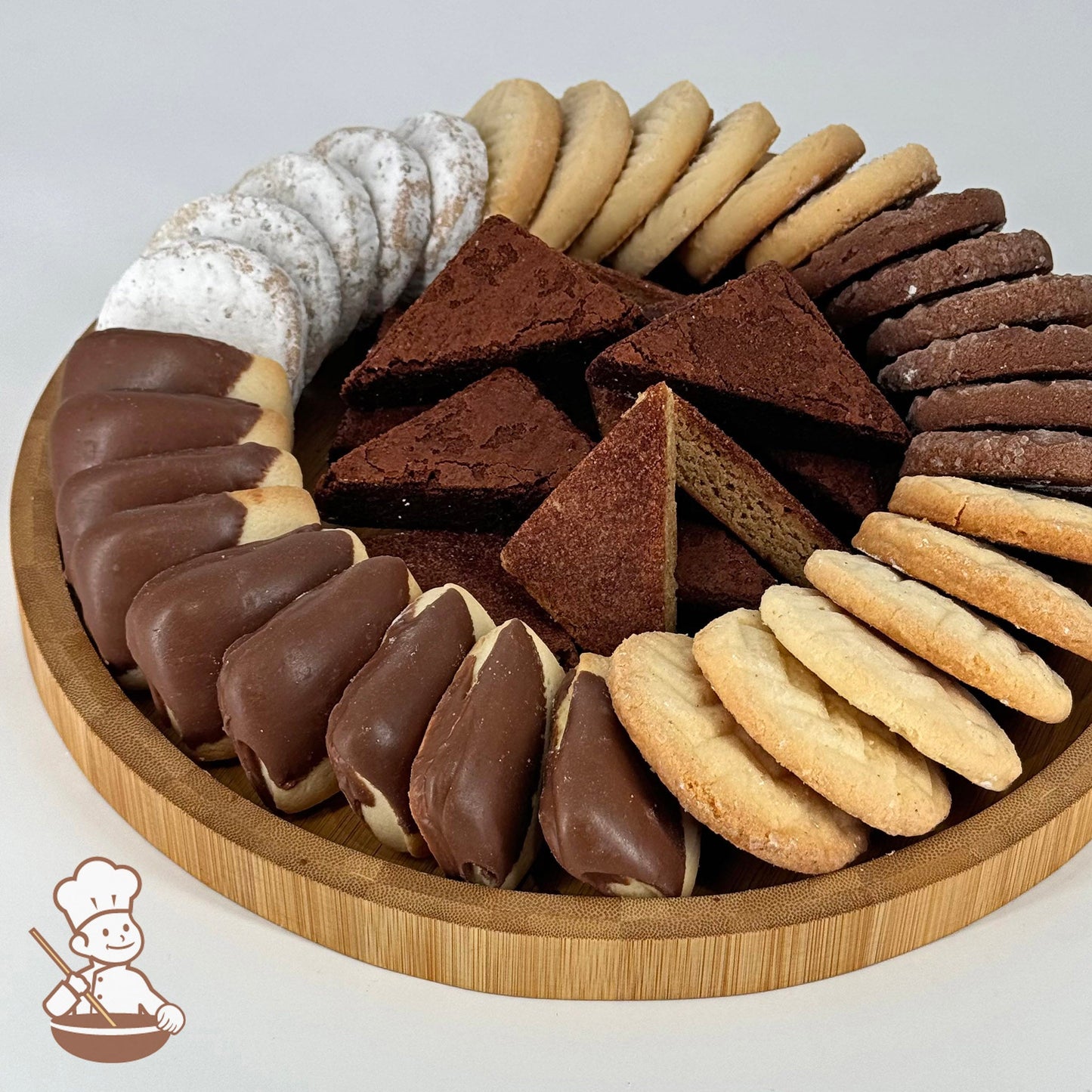 A round bamboo tray holding an assortment of flavored shortbread cookies and brownies.