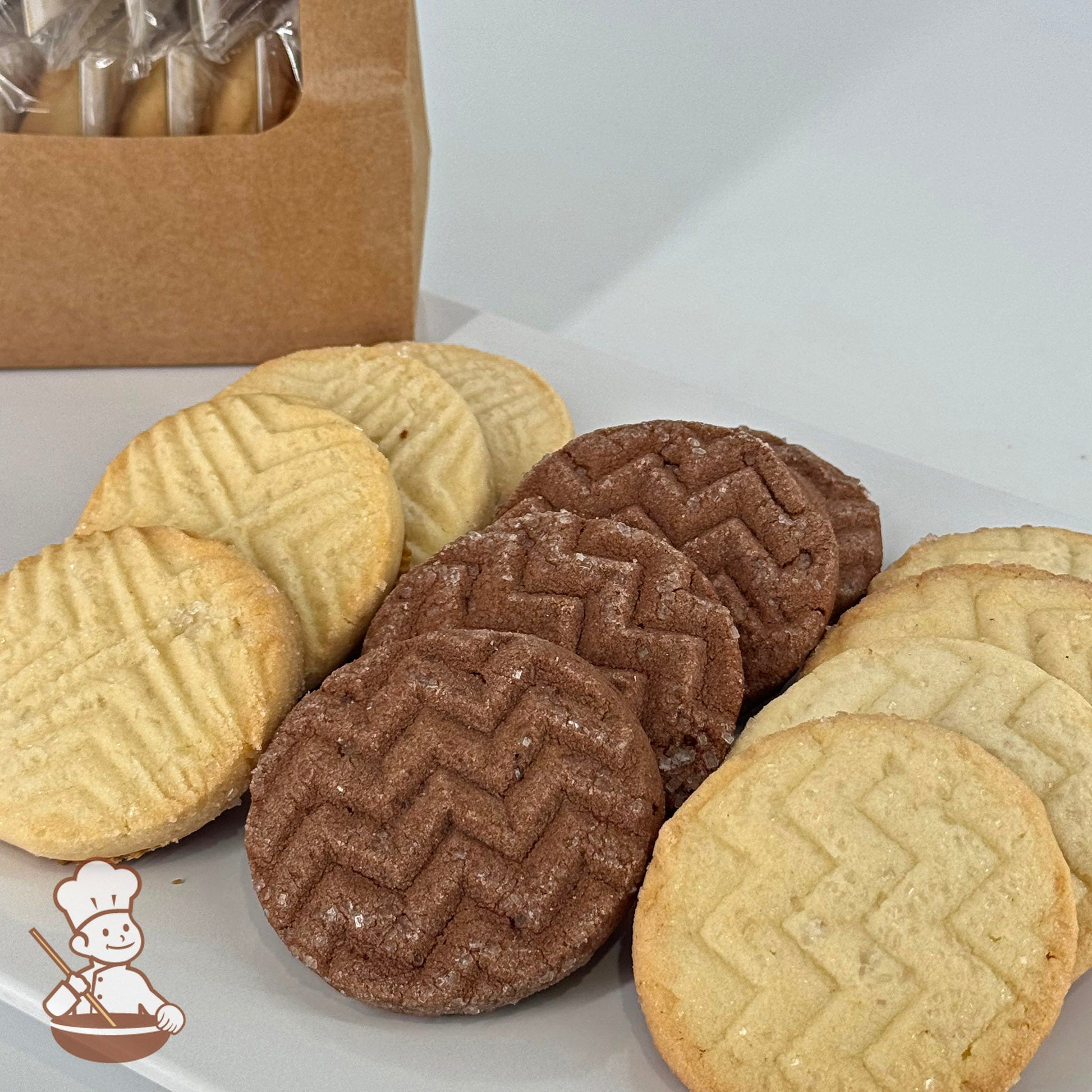 A variety pack of twelve shortbread cookies with four each of butter, lemon, and chocolate flavors, displayed in front of a kraft window bag.