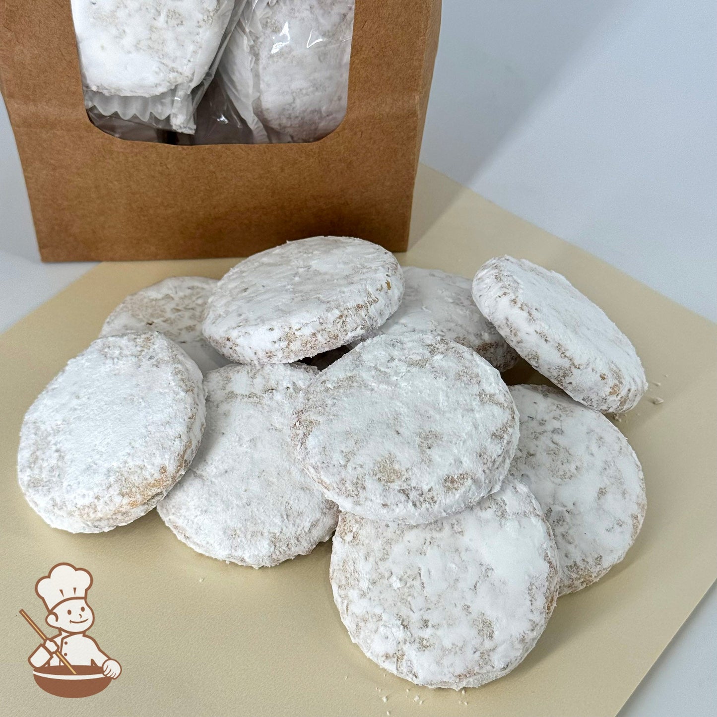 Ten wedding cookies made with walnuts and coated in powdered sugar are arranged in front of a kraft window bag.