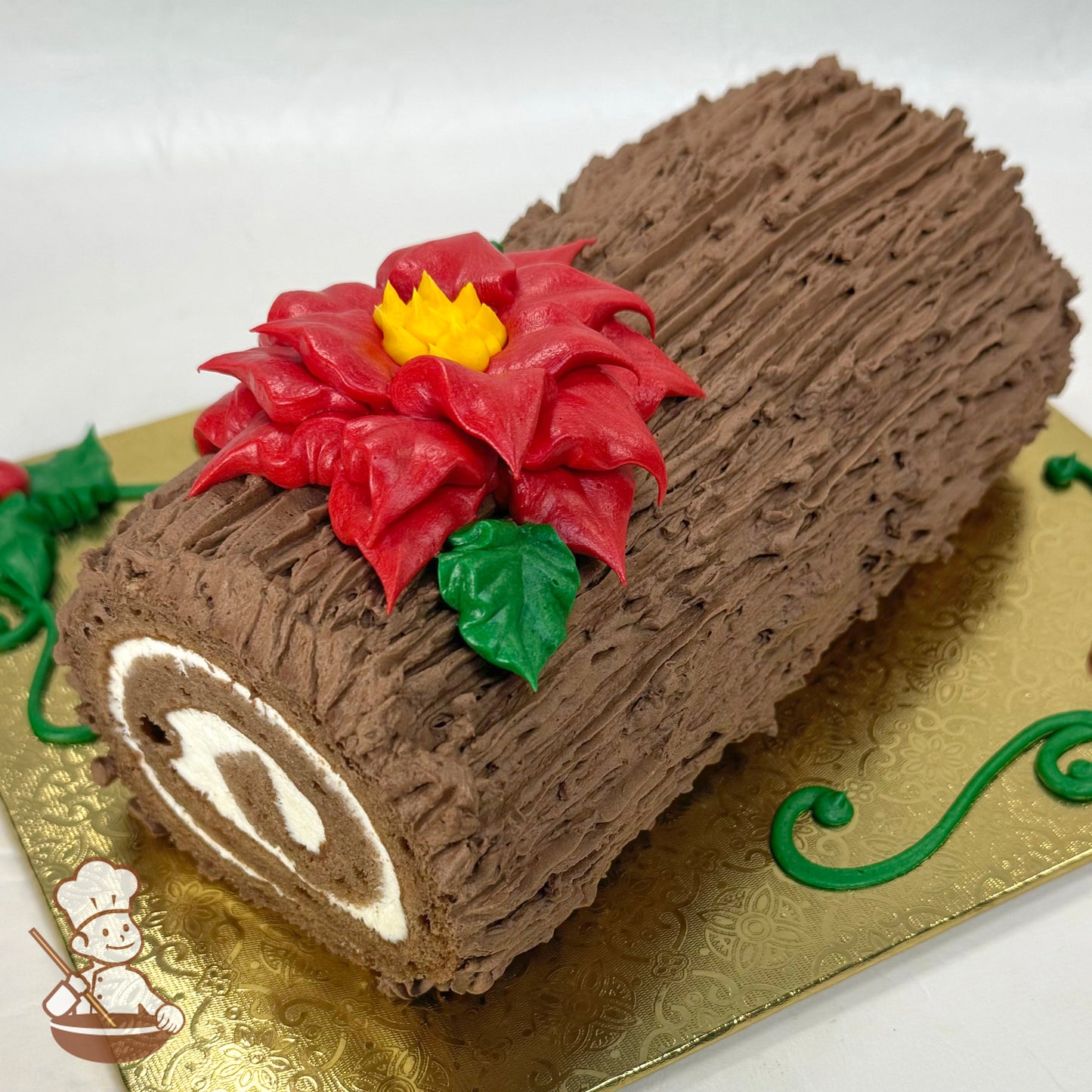 A medium brown yule log cake textured to look like a log with a red buttercream poinsettia on top.