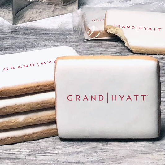 A stack of rectangle butter shortbread cookies with Grand Hyatt logo printed directly on a white, lemon sugar icing.