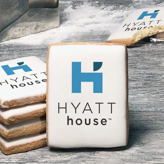 A stack of rectangle butter shortbread cookies with Hyatt House logo printed directly on a white, lemon sugar icing.