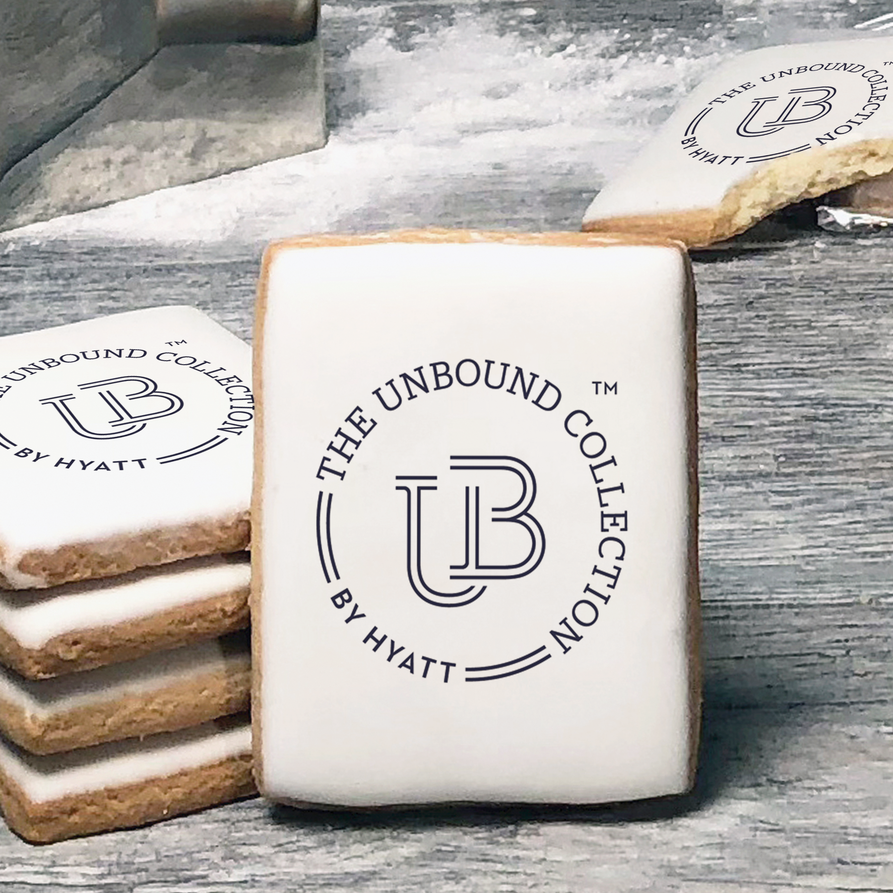 A stack of rectangle butter shortbread cookies with The Unbound Collection by Hyatt logo printed directly on a white, lemon sugar icing.