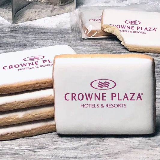 A stack of rectangle butter shortbread cookies with Crowne Plaza logo printed directly on a white, lemon sugar icing.