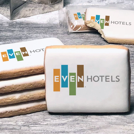 A stack of rectangle butter shortbread cookies with Even Hotels logo printed directly on a white, lemon sugar icing.