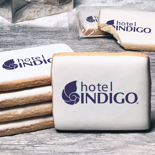 A stack of rectangle butter shortbread cookies with Hotel Indigo logo printed directly on a white, lemon sugar icing.