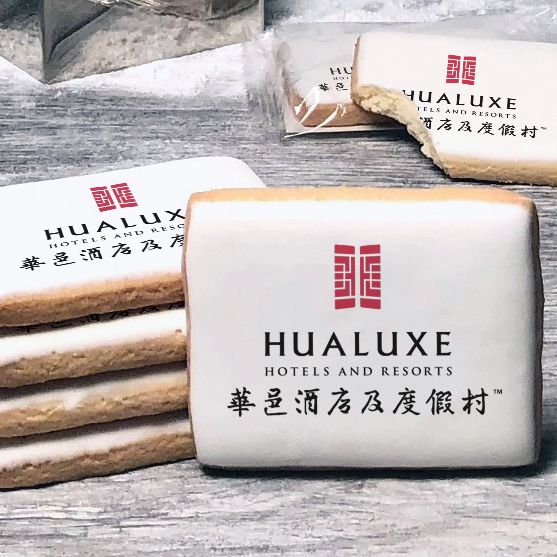 A stack of rectangle butter shortbread cookies with Hualuxe logo printed directly on a white, lemon sugar icing.