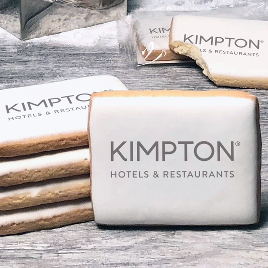 A stack of rectangle butter shortbread cookies with Kimpton logo printed directly on a white, lemon sugar icing.