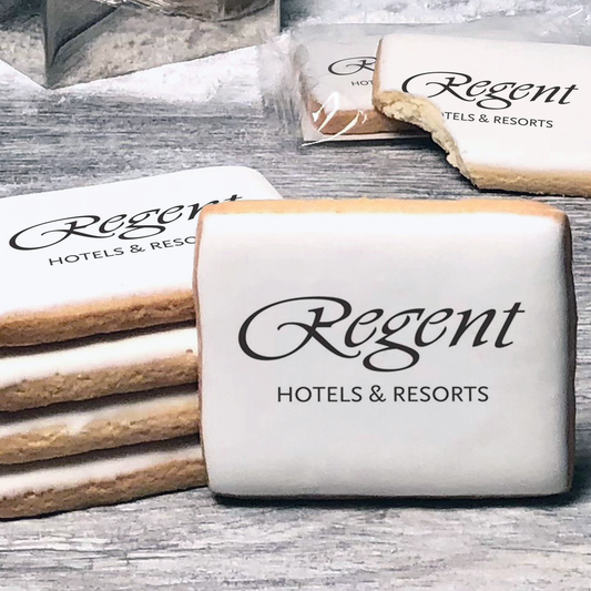 A stack of rectangle butter shortbread cookies with Regent logo printed directly on a white, lemon sugar icing.