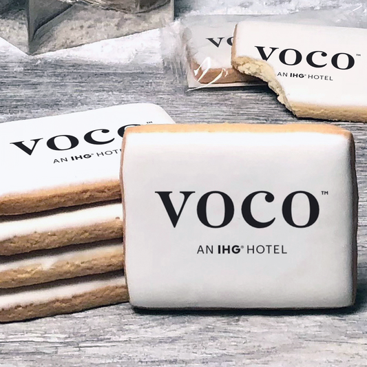 A stack of rectangle butter shortbread cookies with Voco logo printed directly on a white, lemon sugar icing.