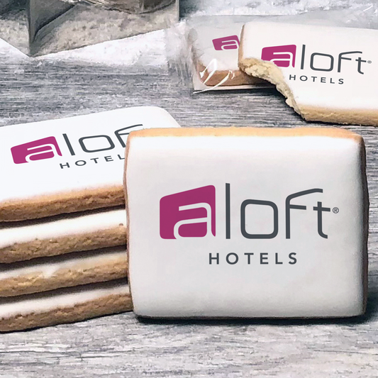 A stack of rectangle butter shortbread cookies with Aloft Hotels logo printed directly on a white, lemon sugar icing.