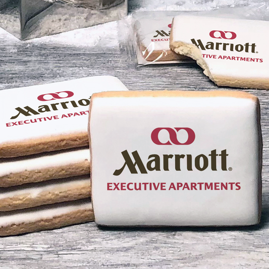 A stack of rectangle butter shortbread cookies with Marriott Executive Apartments logo printed directly on a white, lemon sugar icing.