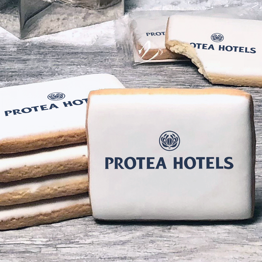 A stack of rectangle butter shortbread cookies with Protea Hotels logo printed directly on a white, lemon sugar icing.