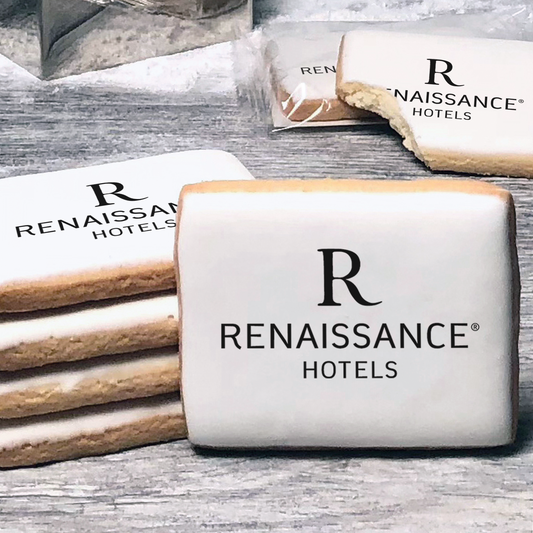 A stack of rectangle butter shortbread cookies with Renaissance logo printed directly on a white, lemon sugar icing.