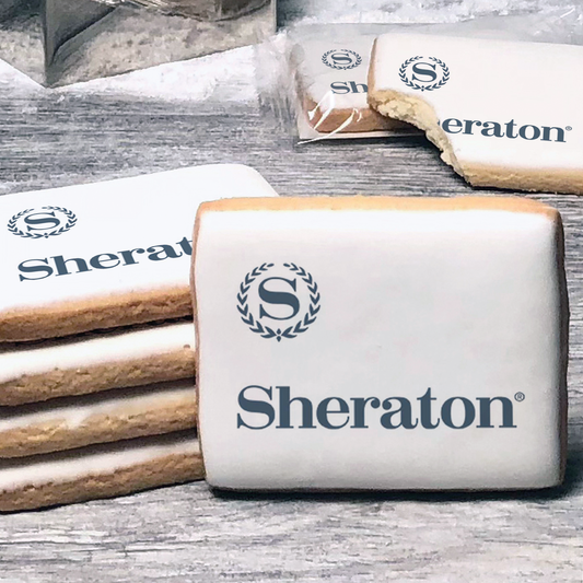 A stack of rectangle butter shortbread cookies with Sheraton logo printed directly on a white, lemon sugar icing.