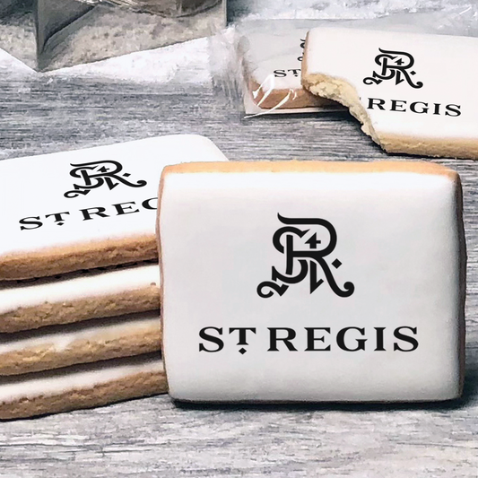 A stack of rectangle butter shortbread cookies with St Regis logo printed directly on a white, lemon sugar icing.