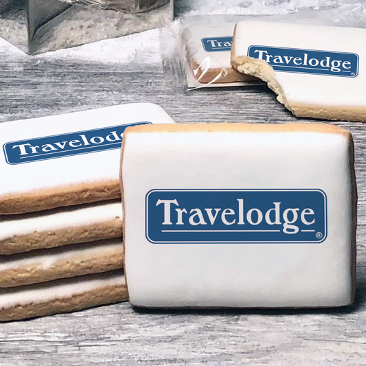 A stack of rectangle butter shortbread cookies with Travelodge logo printed directly on a white, lemon sugar icing.