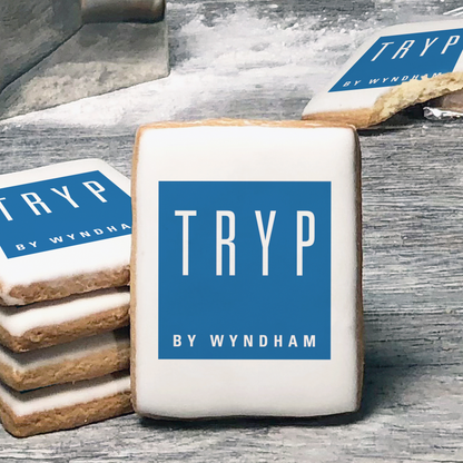 A stack of rectangle butter shortbread cookies with Tryp logo printed directly on a white, lemon sugar icing.