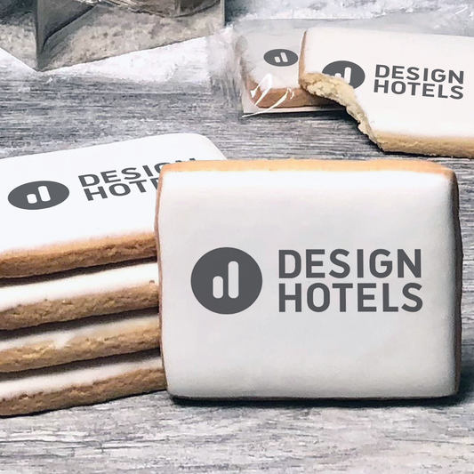 A stack of rectangle butter shortbread cookies with Design Hotels logo printed directly on a white, lemon sugar icing.