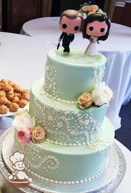 3-tier cake with mint-green tinted buttercream with white buttercream scrolls and fresh flowers.