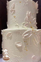 2-tier hand painted baby pink petals on textured cake wall. Decorated with falkes of gold dust.