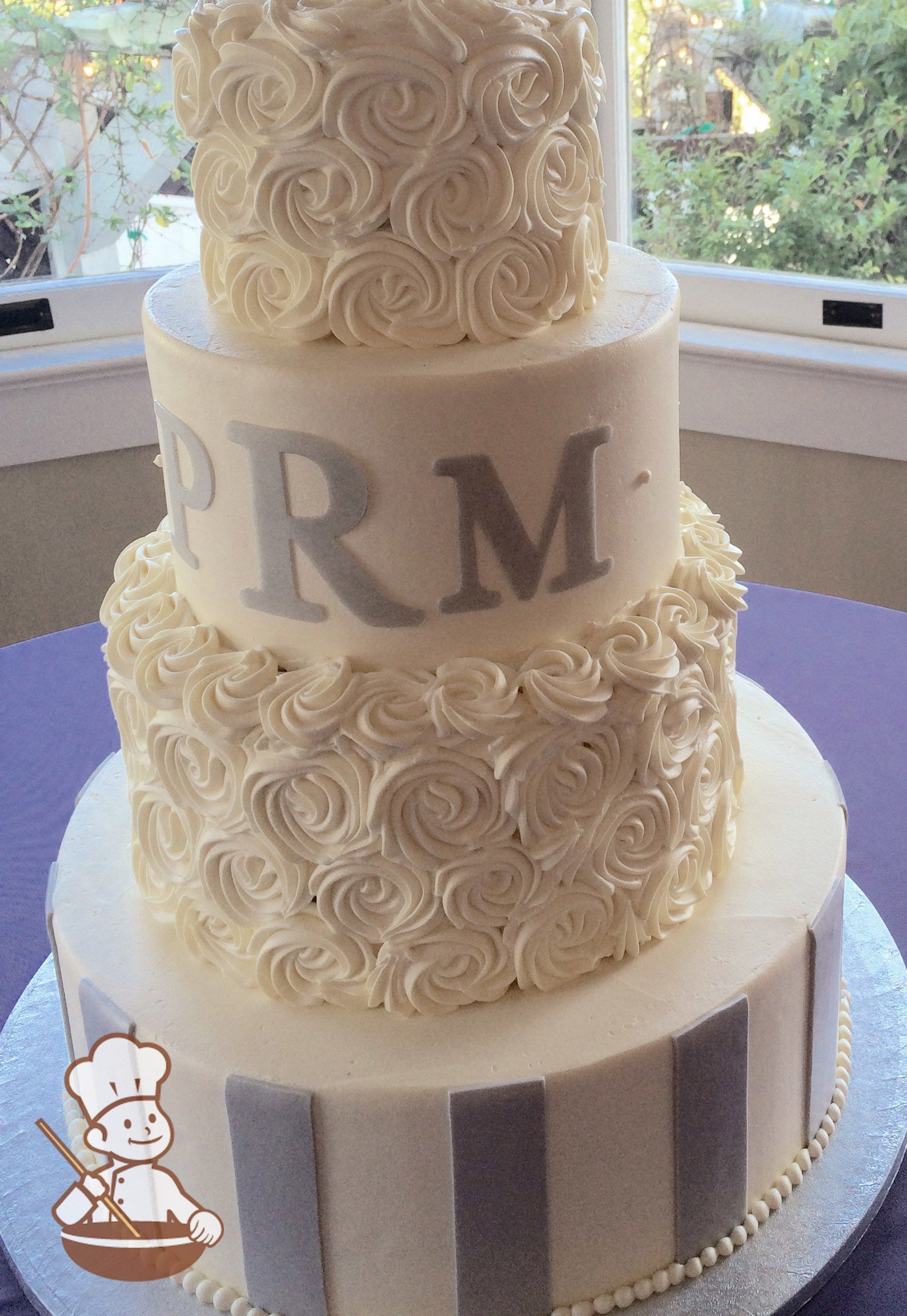 4-tier cake with white icing and decorated with gray fondant stripes on the bottom tier & white buttercream rosettes on the second and top tier.